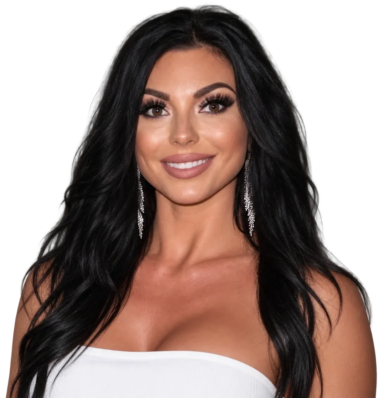 Woman with long black wavy hair, dramatic eye makeup, and dangling silver earrings, smiling at camera