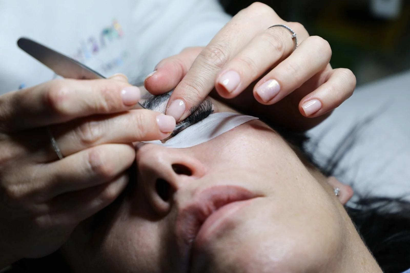 Woman's manicured hands holding newborn baby's face gently