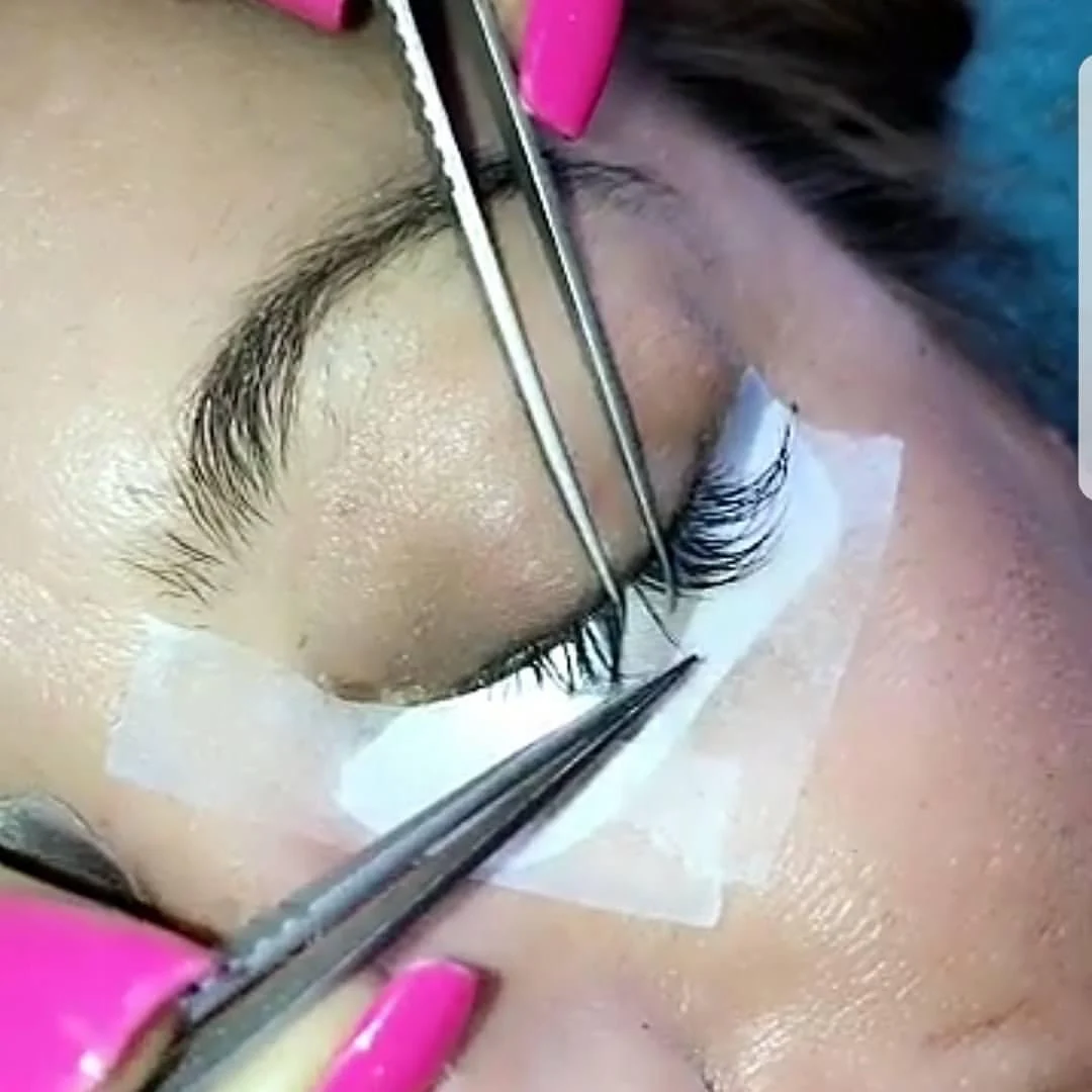 Eyelash extension application with tweezers and white under-eye patches